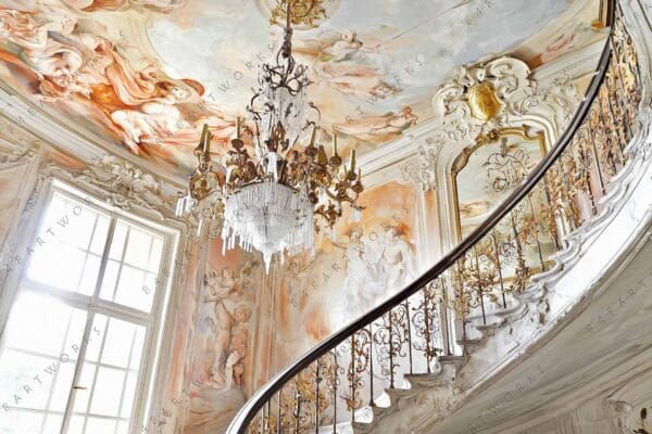 Baroque-style interior with painted ceiling, ornate chandelier, and curved staircase in soft pastels.